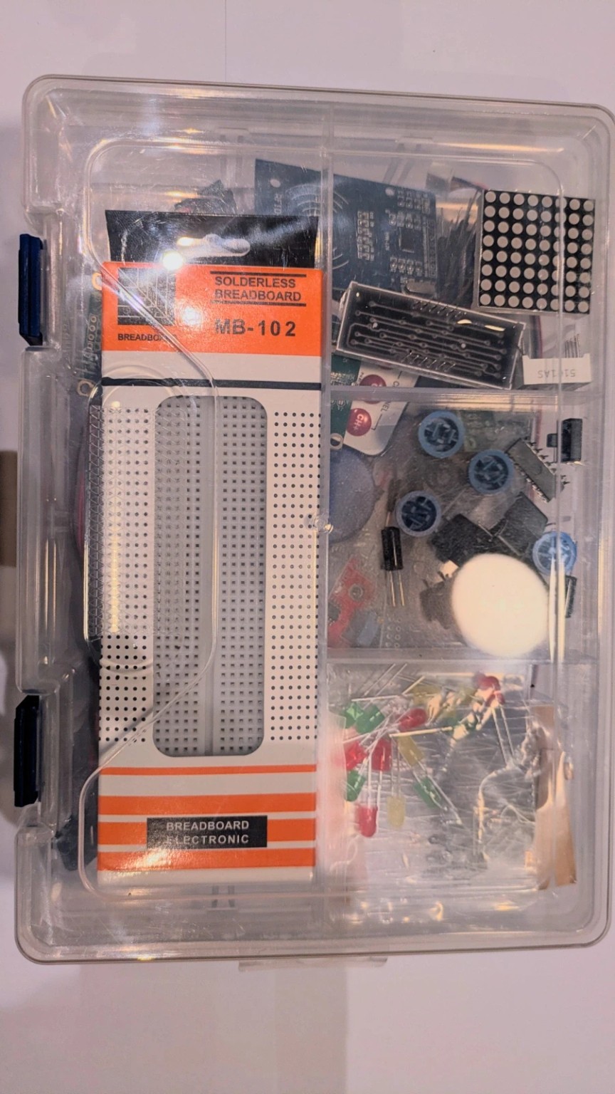 Arduino Uno R3 starter kit components arranged in a clear storage case